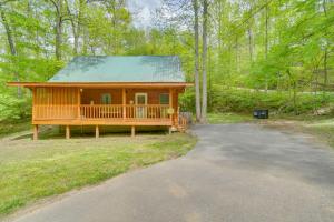 a large wooden cabin in the middle of a forest at Cabin with Hot Tub about 6 Mi to Downtown Gatlinburg! in Gatlinburg