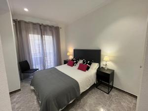 1 dormitorio con 1 cama grande con almohadas rojas en Apartamentos Romero, en Alicante