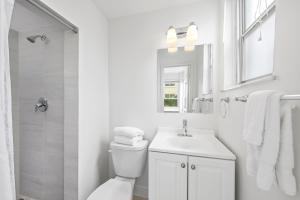 棕櫚灘的住宿－The Ambassador Hotel，白色的浴室设有卫生间和水槽。