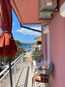 a balcony with a table and chairs and an umbrella at Mare in Brodarica