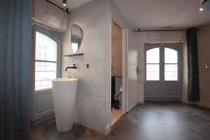 baño con lavabo, espejo y puerta en Le Maje Hostel, en Montpellier