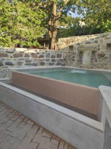 a small pool with a fountain in a stone wall at Fairytale Elafonisi in Perivólia