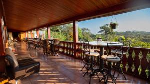 uma varanda com mesas e cadeiras e vista para as árvores em Fondavela Hotel em Monteverde