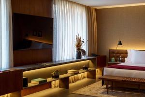 Hotel Fasano Sao Paulo Itaim في ساو باولو: غرفة فندقية بسرير وطاولة ونافذة