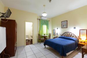 a bedroom with a blue bed and a bathroom at Daher Center Hotel in Sao Paulo