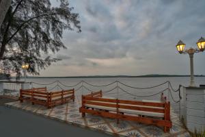two wooden benches sitting next to a body of water at Blu Missel By The River in Panaji