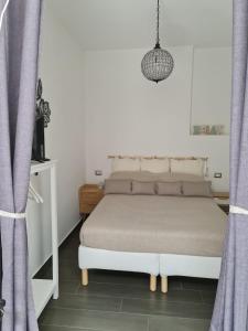 1 Schlafzimmer mit einem weißen Bett und lila Vorhängen in der Unterkunft Geko Suite Toledo in Neapel