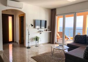 a living room with a couch and a view of the ocean at Seafront 2-bedroom apartment Nika - Rabac in Rabac
