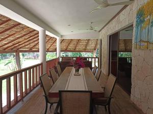 ein Esszimmer mit einem Tisch und Stühlen auf einer Veranda in der Unterkunft Casa Wayil - Comfort y privacidad en la selva 