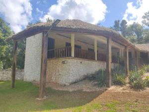 ein Haus mit einer Veranda mit einer Steinmauer in der Unterkunft Casa Wayil - Comfort y privacidad en la selva 