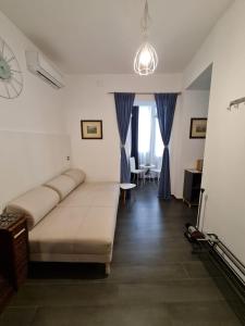 ein Wohnzimmer mit Sofa und blauen Vorhängen in der Unterkunft Geko Suite Toledo in Neapel
