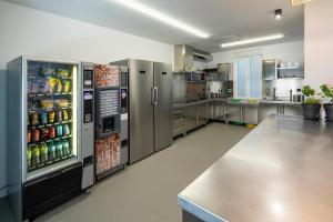a large kitchen with stainless steel refrigerators at Bulezen Urban Hostel in Pontevedra
