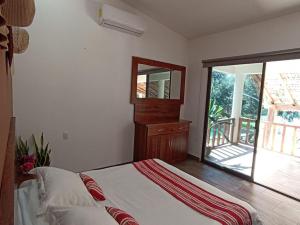 Schlafzimmer mit einem Bett, einem Spiegel und einem Fenster in der Unterkunft Casa Wayil - Comfort y privacidad en la selva 