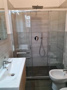 ein Bad mit einer Dusche, einem Waschbecken und einem WC in der Unterkunft Geko Suite Toledo in Neapel