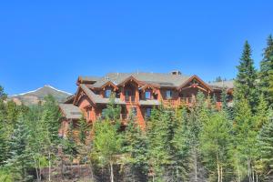 une grande maison en bois située sur une colline dans les bois dans l'établissement Mountain Thunder Lodge, à Breckenridge