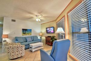 een woonkamer met een blauwe bank en een tv bij Sandpiper 1A in Gulf Shores