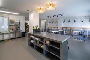 a large kitchen with a large counter with chairs at Bulezen Urban Hostel in Pontevedra