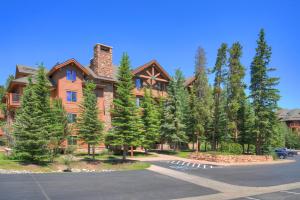 une grande maison en bois avec des arbres devant elle dans l'établissement Mountain Thunder Lodge, à Breckenridge