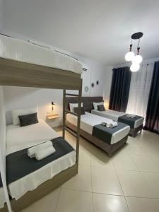 a bedroom with two bunk beds and a couch at Hotel Abedini in Sarandë