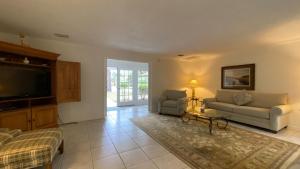 a living room with a couch and a tv at PELICAN HOUSE home in Jekyll Island