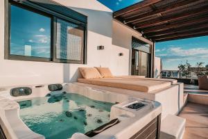 アテネにあるSuites with magical view & jacuzziのマスターベッドルーム(ベッド1台、バスタブ付)