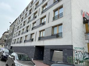 een gebouw waar auto's voor geparkeerd staan bij Happy House Apartamenty in Krakau