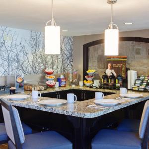 uma grande ilha num restaurante com cadeiras azuis em Staybridge Suites Fairfield Napa Valley Area, an IHG Hotel em Fairfield