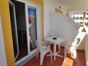 una pequeña mesa y sillas en una habitación con ventana en Casa Mar Azul, en Vila Nova de Milfontes