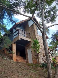 una casa de piedra con un balcón en un lateral. en Pousada Alto Itaipava, en Itaipava