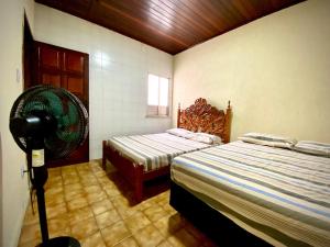 1 Schlafzimmer mit 2 Betten und einem Ventilator in der Unterkunft Casa no Centro, Home Office com ar condicionado in Aracaju