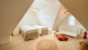 a attic room with two beds and a crib at House Santa Maria in De Haan