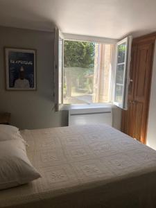 Un dormitorio con una cama grande y una ventana en Petite maison entourée de lavande dans le Lubéron, en Banon
