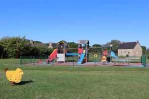 un parque con parque infantil con un juguete de mono en el césped en CHAMBRES D'HÔTES AU DETOUR DU MONT St Michel en Roz-sur-Couesnon