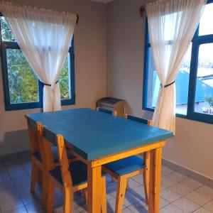 une table bleue avec deux chaises et deux fenêtres dans l'établissement EsKel I, à Esquel