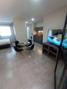 uma sala de estar com uma mesa de jantar e uma televisão em Tres Chihuahuas & Spa em Mariano Moreno