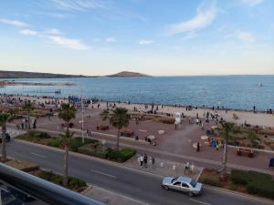 ein Auto, das auf einer Straße neben dem Meer parkt in der Unterkunft Residence La corniche Étage 2 in Nador