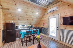 a kitchen with a table with chairs and a refrigerator at Cozy Alabama Retreat with Hot Tub, Near Ruby Falls! in Bryant