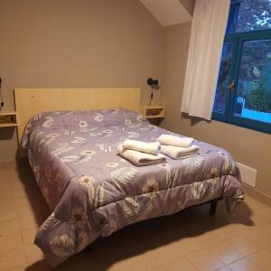 - une chambre avec un lit et des serviettes dans l'établissement EsKel I, à Esquel
