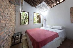 une chambre avec un lit et un mur de briques dans l'établissement Casa em meio a natureza - Ideal para casal, à Rio de Janeiro 26 autres photos
