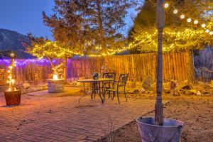 een patio met een tafel, stoelen en verlichting bij Lodge at Poncha Springs in Salida