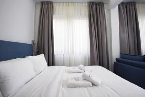 a bedroom with a white bed with towels on it at TiP - ToP Suites in Athens