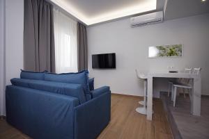 a living room with a blue couch and a table at TiP - ToP Suites in Athens