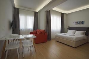 a bedroom with a bed and a table and a chair at TiP - ToP Suites in Athens