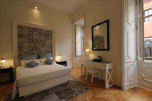 a bedroom with a bed and a desk and a mirror at Residenza L'angolo di Verona in Verona