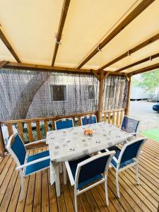 a white table and chairs on a wooden deck at Mobil home 8 personnes camping L'Elysée Vagues Océanes in Le Grau-du-Roi