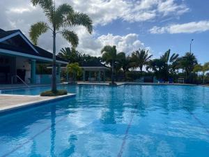 uma grande piscina azul com palmeiras ao fundo em Island Style Villa in Richmond Estate Palms em Banks