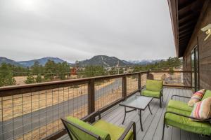 a balcony with chairs and a table and a view at Coyote Mountain Lodge in Estes Park