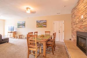 a dining room with a table and a fireplace at Coyote Mountain Lodge in Estes Park