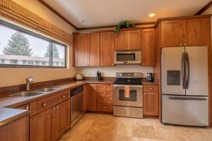 una cocina con armarios de madera y electrodomésticos de acero inoxidable en Coyote Mountain Lodge, en Estes Park