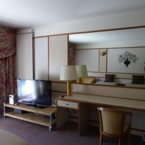 a hotel room with a television and a desk with a lamp at Château de Bazeilles in Bazeilles